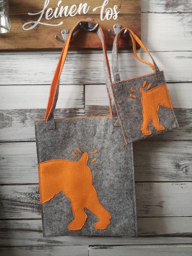 grauer Filzbeutel mit orangenem Hundeaufdruck