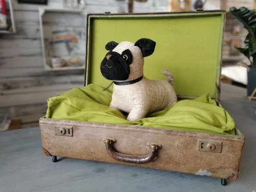 Stoffhundeliegekissen in altem Reisekoffer mit Stofftier